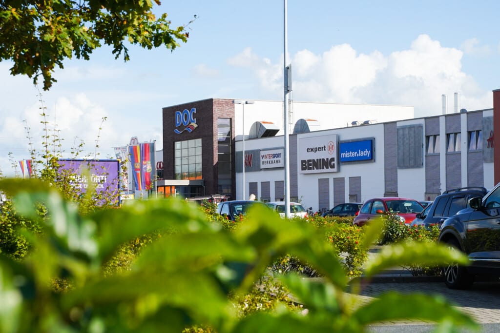 Aussenansicht linker Eingang vom DollartCenter in Emden durch eine Pflanze fotografiert